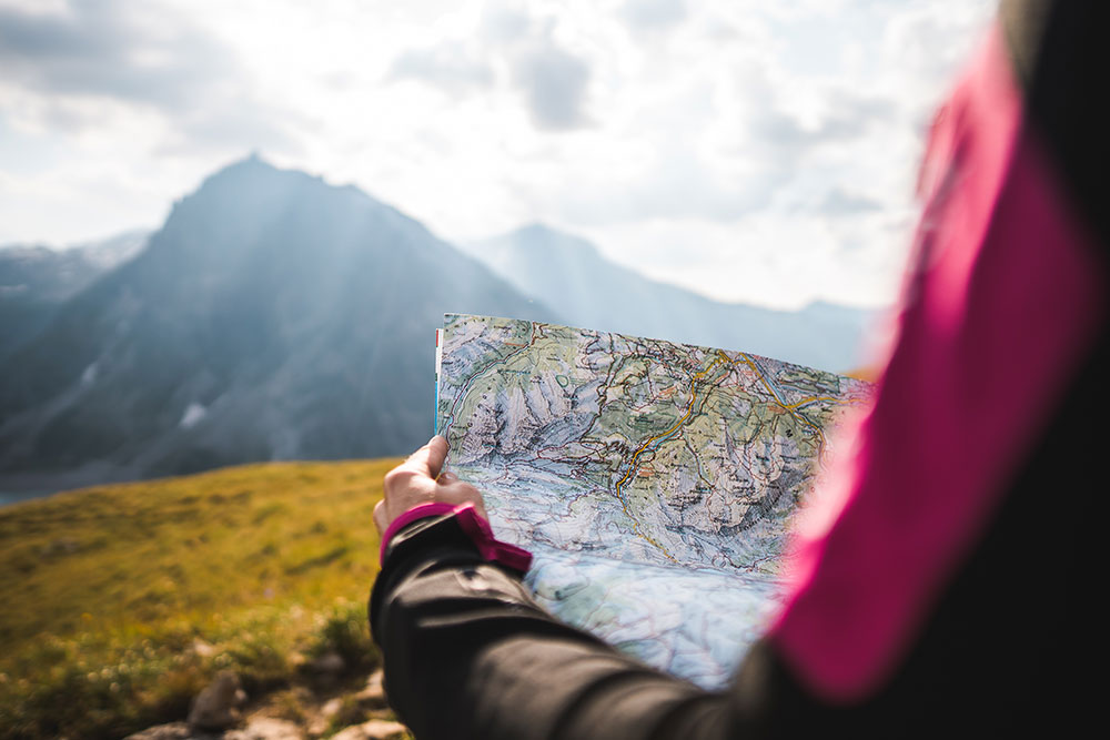 Girl-with-a-map-on-a-mountain